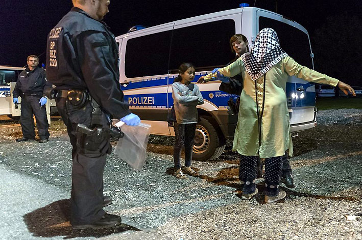 Une policière contrôle une réfugiée et sa fille à la frontière germano-autrichienne - © Libération